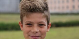 boy in yellow crew neck shirt smiling