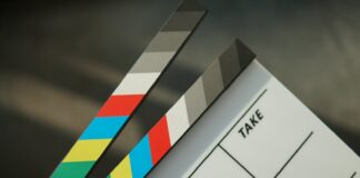 A person holding a clapstick in their hand