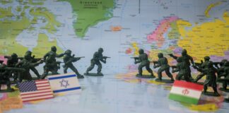Toy soldiers face off on world map with flags.