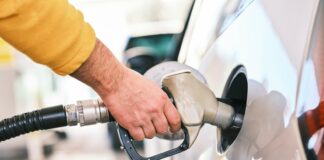 a man pumping gas into his car at a gas station