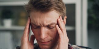 a man holding his hands to his ears