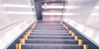 an escalator with yellow bars going down it