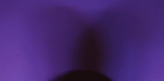 a man standing in front of a purple wall