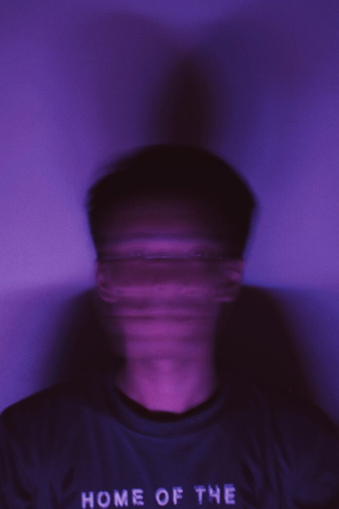 a man standing in front of a purple wall