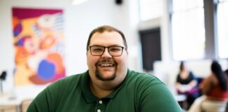 man sitting down wearing green polo shirt