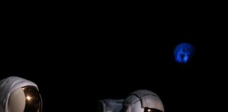 two astronauts standing on the surface of the moon