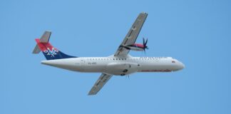 An airplane is flying in a blue sky.