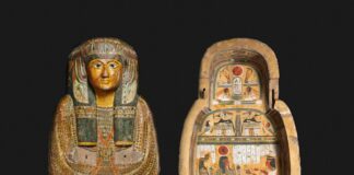 Ancient egyptian sarcophagus with painted hieroglyphs and figures.