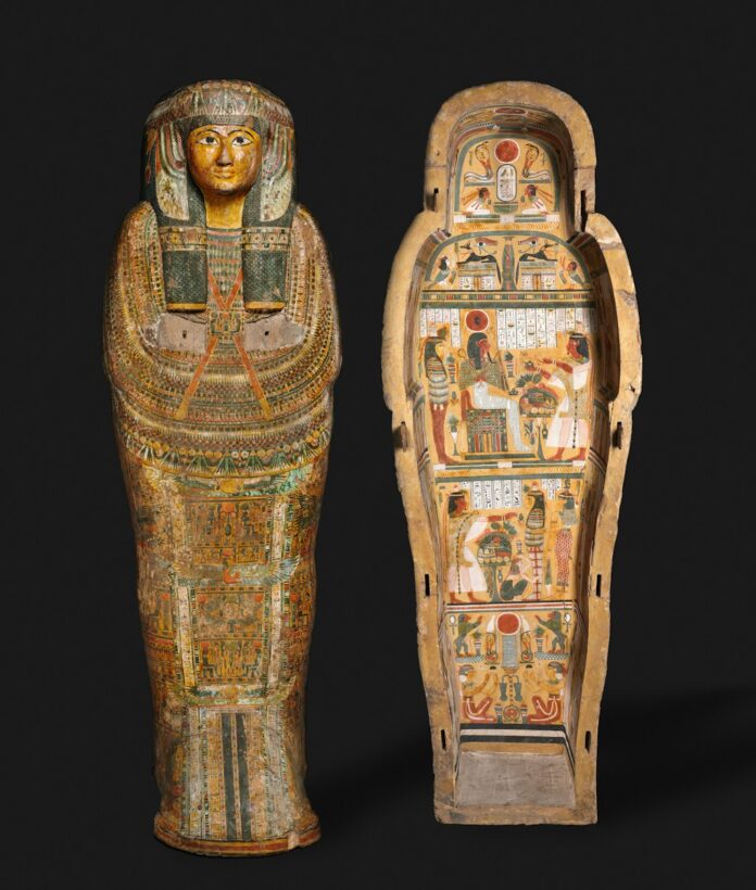 Ancient egyptian sarcophagus with painted hieroglyphs and figures.