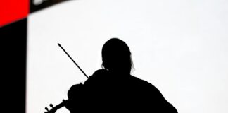 silhouette of woman playing guitar