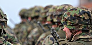 man in green and brown camouflage uniform holding black rifle
