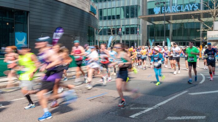Runners participate in a marathon on a city street.