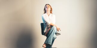 a woman sitting on top of a stool