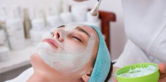 woman lying on blue towel with white cream on face