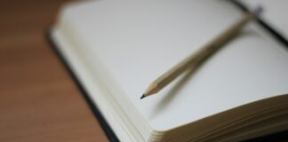 shallow focus photography of pencil on book