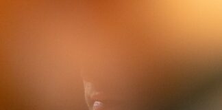 A man is partially visible, blurred by light.