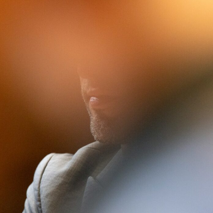 A man is partially visible, blurred by light.