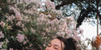 woman standing beside white bougainvilleas
