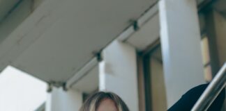a woman with long hair standing on a stair case
