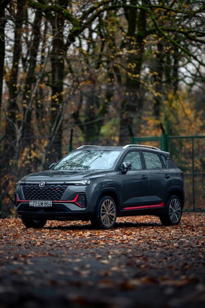 A black car parked in front of a fence