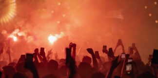 a crowd of people holding up their cell phones