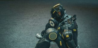 A futuristic robot sits on the floor.