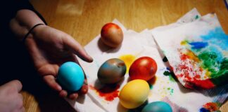 person holding red yellow and blue egg