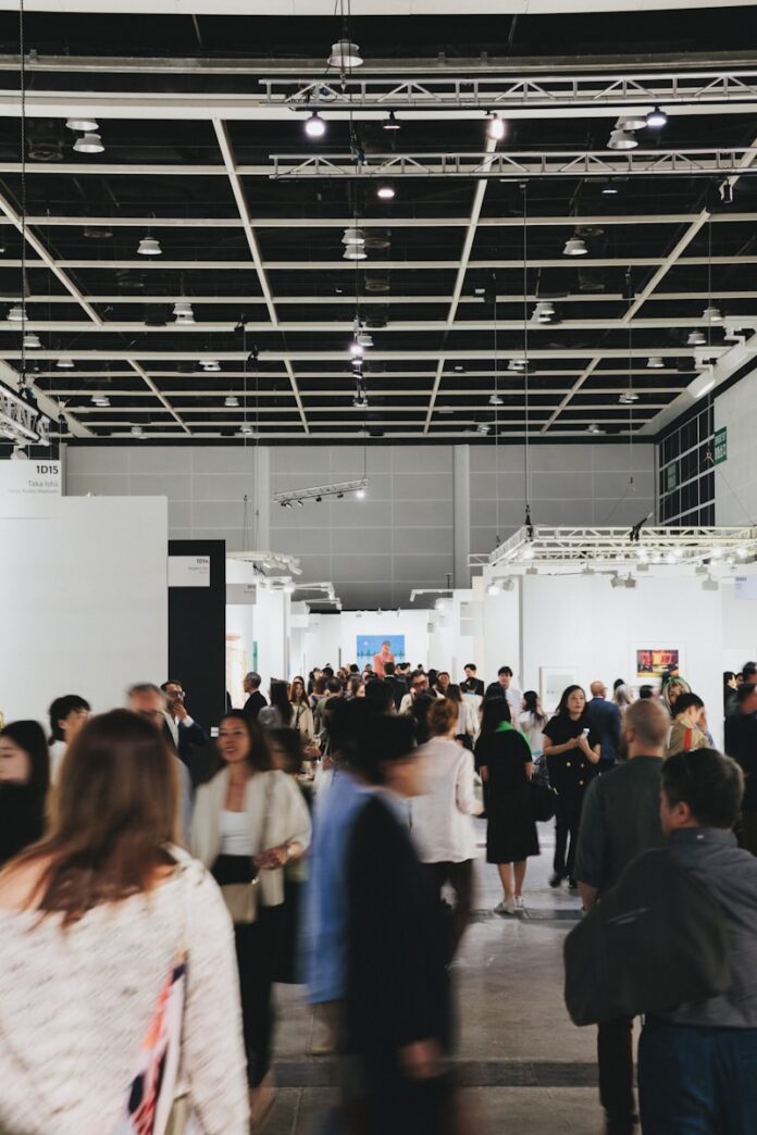 People browse art in a busy, modern gallery.