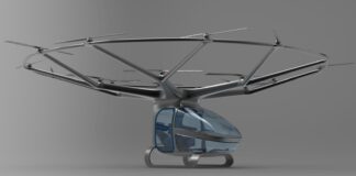 A small blue helicopter is flying in the air