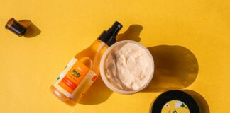 a bottle of sunscreen and a jar of sunscreen on a yellow surface