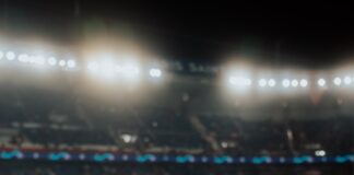 a person sitting on a bench watching a soccer game