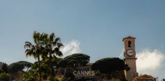 a clock tower on top of a building next to palm trees