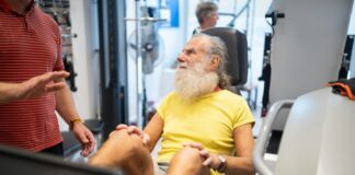 a man with a white beard sitting in a gym