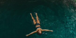 woman in black bikini swimming in water