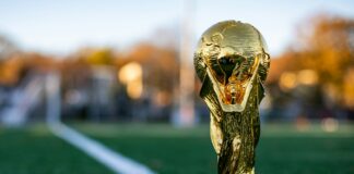 a golden trophy sitting on top of a lush green field