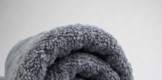 a gray towel folded on top of a bed