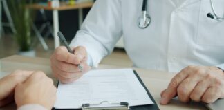 Doctor writing on a patient's chart
