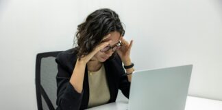 a woman sitting in front of a laptop computer