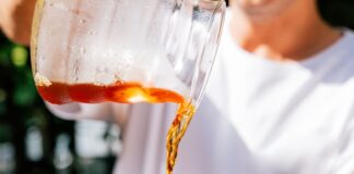 a man is pouring a drink into a glass