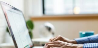 person typing on silver MacBook