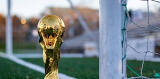 a golden soccer trophy sitting on top of a soccer field