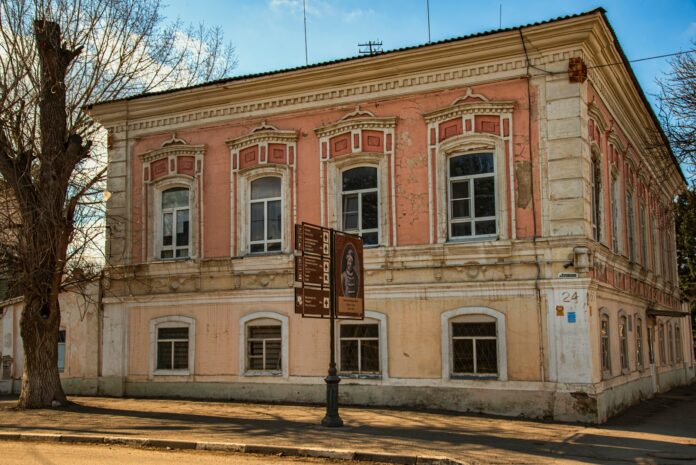 A pink and yellow historic building with ornate windows.