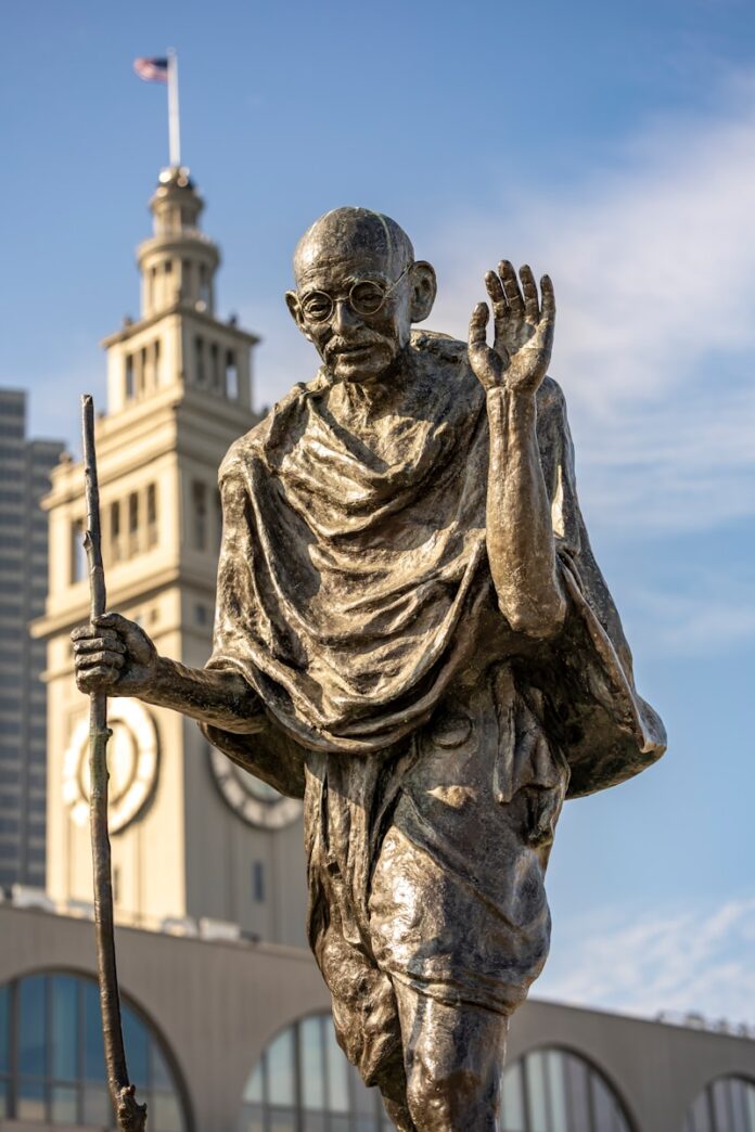 Bronze statue of mahatma gandhi holding a staff.
