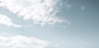 body of water under white clouds