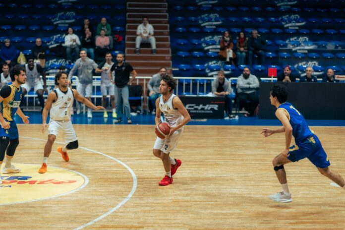 Basketball players competing on a wooden court
