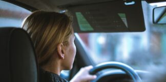 a woman sitting in a car with a steering wheel