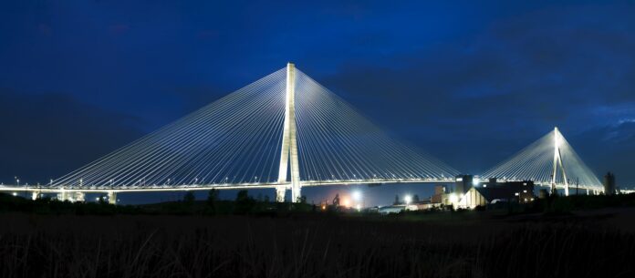 Cable-stayed bridge brightly lit at night.