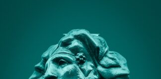 green concrete statue of man