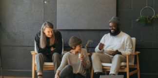 Three coworkers sitting together laughing Surface laptop on furniture