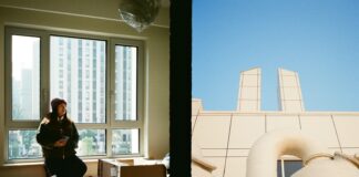 Person by window with boxes, industrial building exterior.